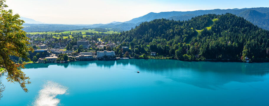 Great drone view panorama of Lake Blead with blue sky and sun reflections on the water, Slovenia.