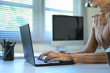 Close up of woman typing on laptop at desk, symbolizing productivity, and modern remote work