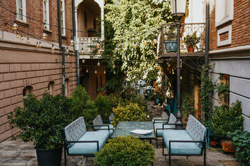 Inviting outdoor seating area surrounded by greenery in a charming alley