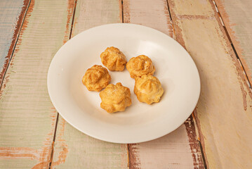 Lemon fritters with citrus glaze, decorated with yellow lemon zest and powdered sugar,
