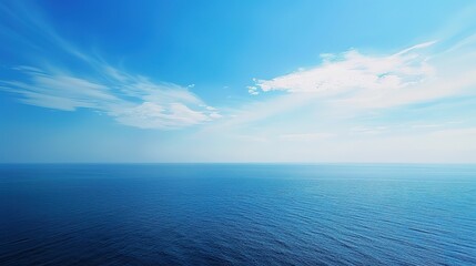 Obraz premium Serenity Unbound: Breathtaking Scene of Blue Sky and Vast Sea – A Clear, Azure Sky Stretching Endlessly Above a Calm, Deep Blue Sea, Where the Horizon Blends Sky and Water into a Soft Line