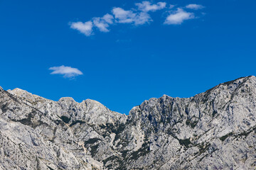 Gray rocks with small vegetation against the sky. Mountain landscape, Croatia. copy space