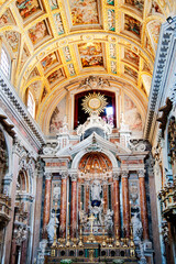 Inside the church of Ges&ugrave; Nuovo or Trinit&agrave; Maggiore in the city's historic center of Naples, Italy. Main altar with marble, columns, precious sculptures, stucco, fresco and decorations. 