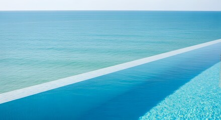 Fototapeta premium The edge of a luxurious infinity pool perfectly blends with the turquoise ocean horizon in this ultra-detailed photograph