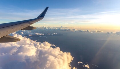 Naklejka premium High-altitude view of clouds and land from an airplane window at sunset