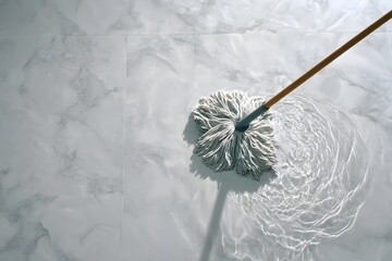 White mop cleaning wet marble floor.