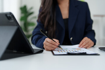 Businesswoman analyzing financial charts and graphs at office desk