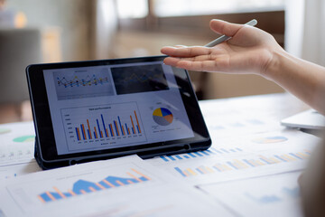Confident businesswoman working at desk with computer in office, smiling while focusing on tasks, symbolizing success, motivation, persistence, and professionalism.
