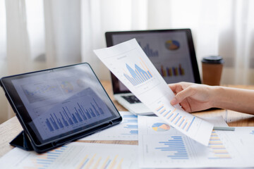 Confident businesswoman working at desk with computer in office, smiling while focusing on tasks, symbolizing success, motivation, persistence, and professionalism.
