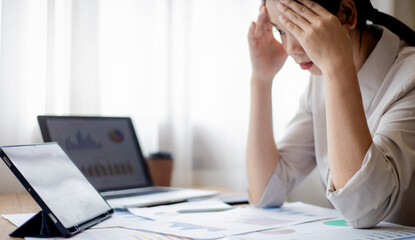 Overworked young businesswoman sleeping at office desk with laptop, symbolizing exhaustion, stress, deadlines, workplace challenges, and modern professional lifestyle.
