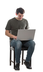 Creative young man freelancer working on laptop seated on a chair. Cheerful positive guy playing video games on his notebook isolated on transparent background, full length portrait