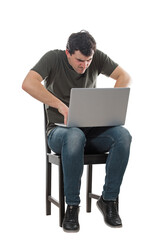 Furious man internet hacker using laptop, typing different codes on keyboard. Irritated freelancer or programmer guy working mad at his notebook. Male data thief seated full length portrait isolated