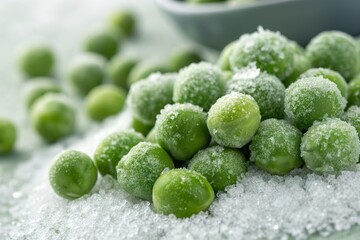 Fresh green peas sprinkled with ice crystals on a surface, with a bowl in the background