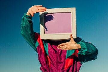 Retro business employee in 90s tracksuit with CRT monitor head outdoors