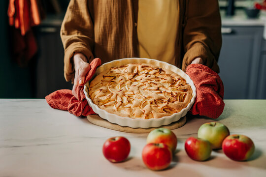 Charlotte pie baking in cozy country kitchen with apples in autumn
