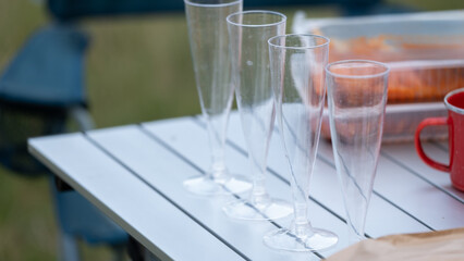 Plastic champagne glasses on outdoor picnic table