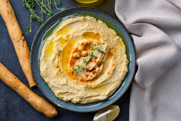 A traditional dish or appetizer hummus or baba ghanoush on black  background