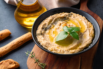 A traditional dish or appetizer hummus or baba ghanoush on black  background
