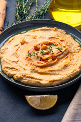 A traditional dish or appetizer hummus or baba ghanoush on black  background