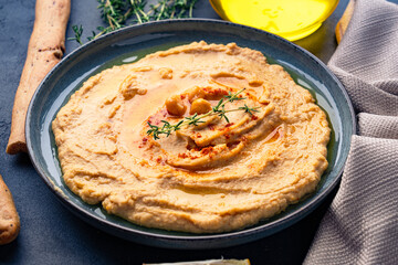 A traditional dish or appetizer hummus or baba ghanoush on black  background