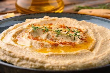A traditional dish or appetizer hummus or baba ghanoush on wooden  background