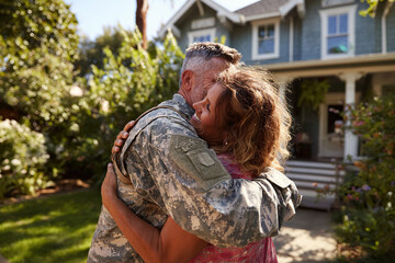 An American soldier returns home after serving in the army. His wife hugs her husband who has returned from the army.