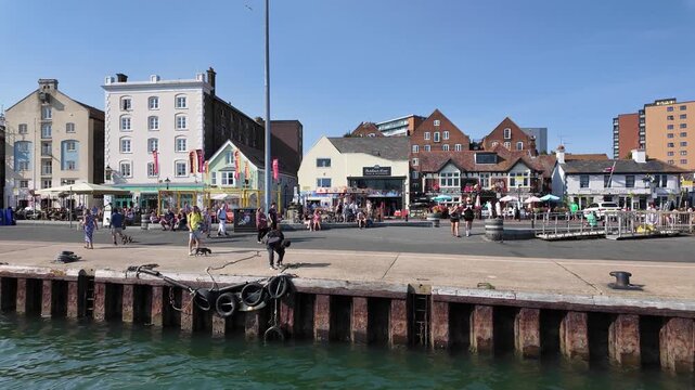 Poole Dorset England UK. 28.08.2025. Video, Coming alongside Poole Quay  viewing the seafront pubs restaurants and holiday activities on the quayside.
