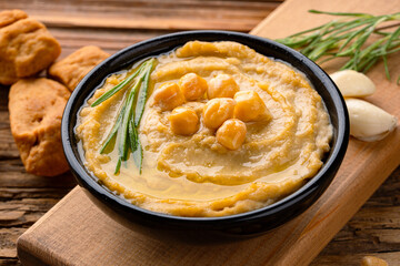 A traditional dish or appetizer hummus or baba ghanoush on wooden  background