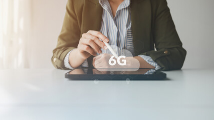 A business professional using a digital tablet with a stylus, highlighting the futuristic concept of 6G technology, innovation, and advanced wireless communication for future networks.