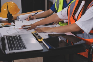 Closeup of team of industrial engineers meeting analyze machinery blueprints consult project on...