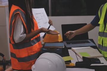 Closeup of team of industrial engineers meeting analyze machinery blueprints consult project on...