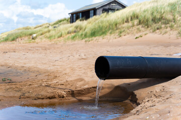 The Pollution Pipe Discharging Waste Water Contaminates the Sandy Beach Area Significantly