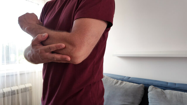 Man with elbow pain at home.