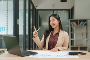Asian businesswoman having video call and explaining charts in the office
