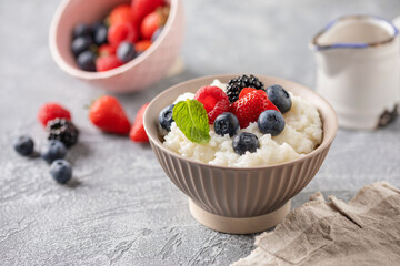 Rice milk porridge in with berries in a bowl on the table. Healthy breakfast
