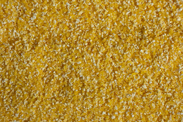 Top view of raw uncooked corn grits, textured cooking background