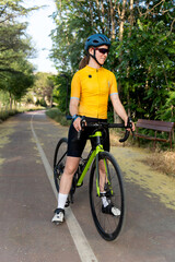 Obraz premium Female cyclist taking a break on bike path in park