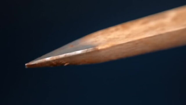 Macro shot of metal chisel tool edge sharpness against dark background