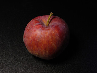 A Single Dark Red Apple on Black