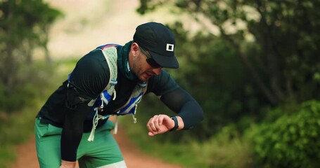 Tired, runner and smart watch with man in nature for workout time lap, cardio fatigue and fitness. Exercise rest stop, training stats and exhausted with person in forest for heart rate tracking - Powered by Adobe