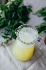 Homemade lemonade with mint, lemon and lime in a glass pitcher on the table. Refreshing drink, nutrition, healthy lifestyle