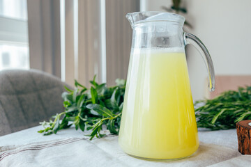 Homemade lemonade with mint, lemon and lime in a glass pitcher on the table. Refreshing drink, nutrition, healthy lifestyle