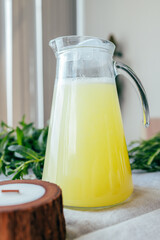 Homemade lemonade with mint, lemon and lime in a glass pitcher on the table. Refreshing drink, nutrition, healthy lifestyle