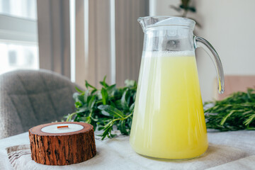 Homemade lemonade with mint, lemon and lime in a glass pitcher on the table. Refreshing drink, nutrition, healthy lifestyle