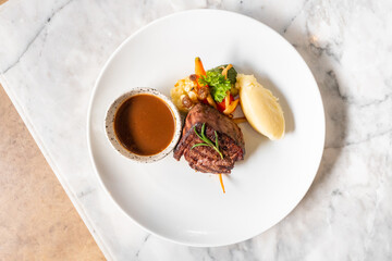 Gourmet Meal on White Plate: Culinary artistry comes alive, presenting a meticulously arranged gourmet meal on a pristine white plate. Succulent steak meets a symphony of flavors.
