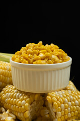 Fresh Corn Cobs And Canned Corn Kernels In White Bowl.