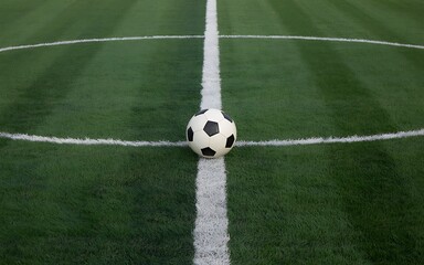 Soccer ball on a green artificial turf field with white line markings perfect for sports and recreation concepts