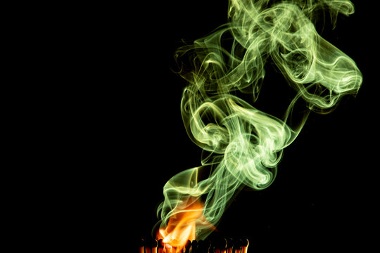 cerillas encendidas con humo verde y fondo negro