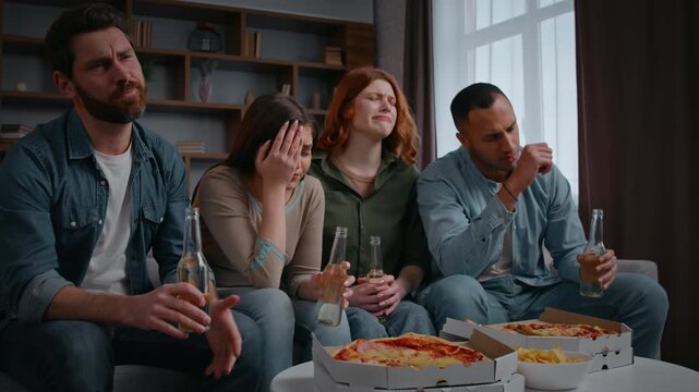 Four friends watching television frustrated reaction disappointed group of diversity people buddies home party with beer pizza food multiethnic women men focused on sport online game fans watch tv sad