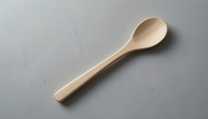 Simple wooden spoon on a neutral gray background